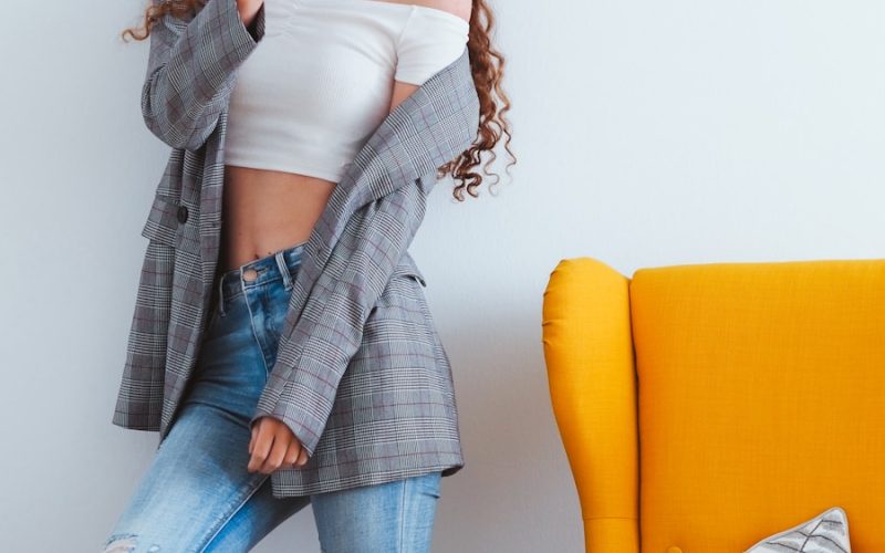 woman in blue denim jeans sitting on yellow couch